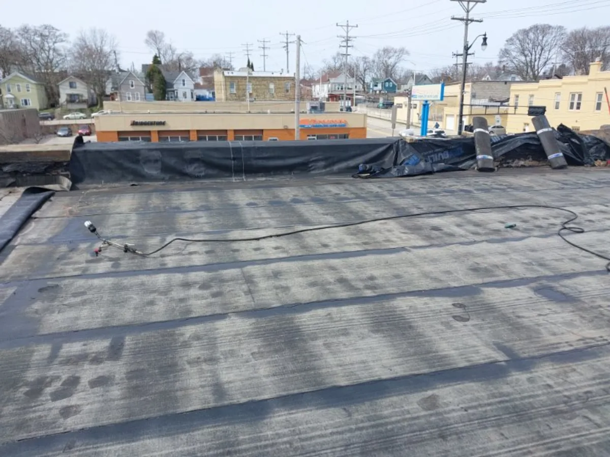 Flat roof replacement in progress on a commercial building