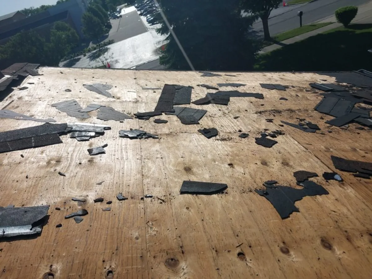 Roof tear off with exposed plywood decking and debris