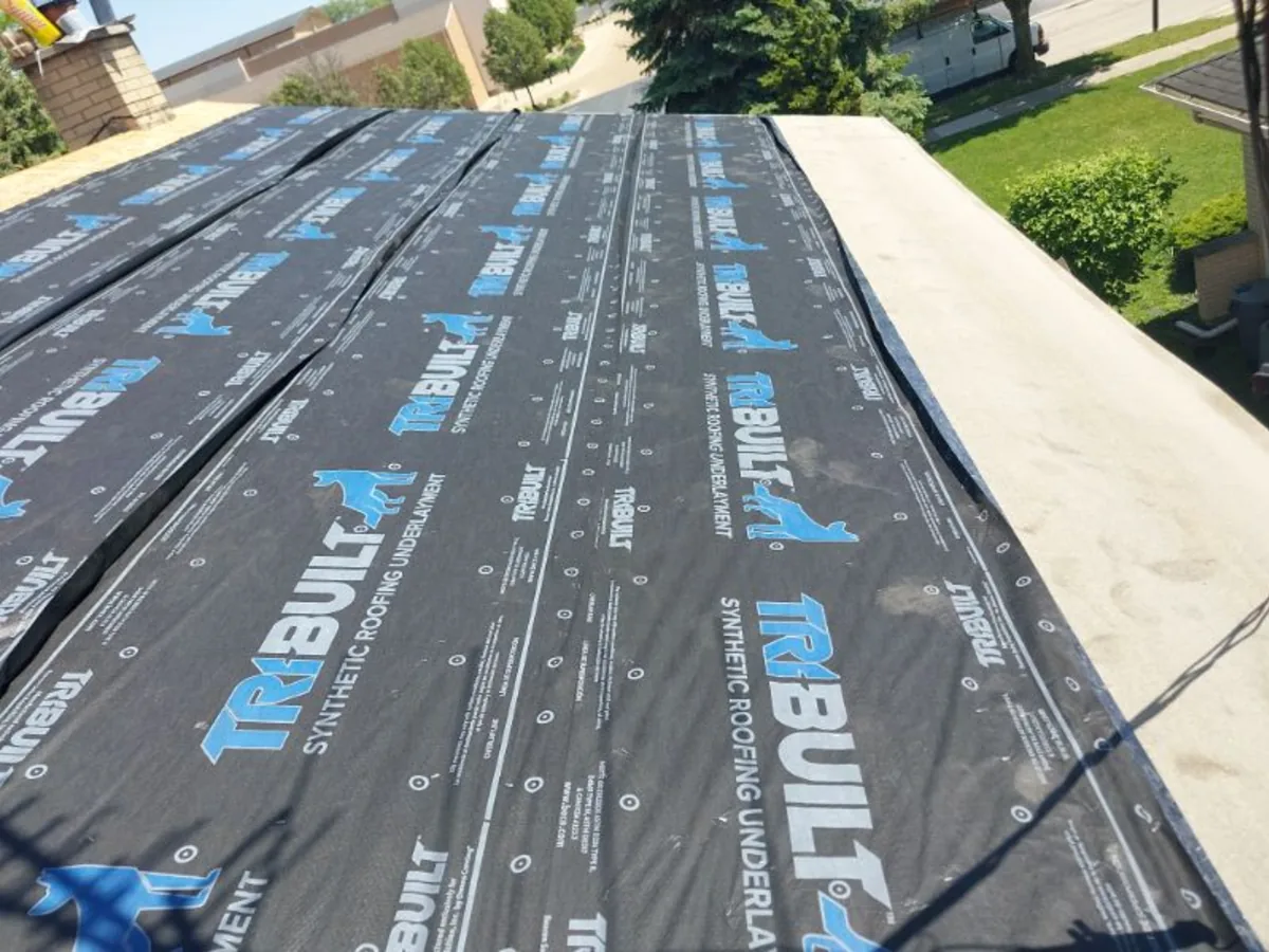 Synthetic underlayment rolled over a sloped roof deck