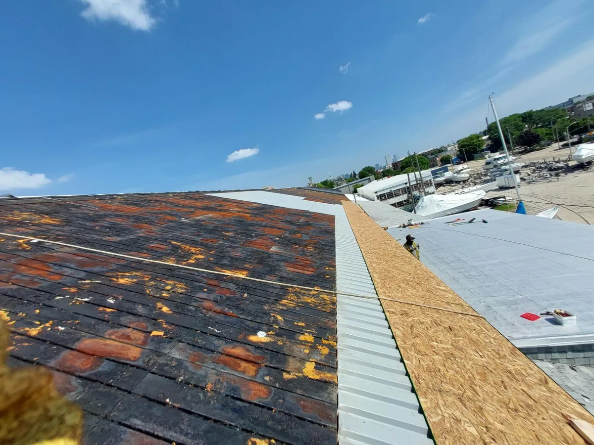 Worn asphalt shingles on a roof edge before tear off